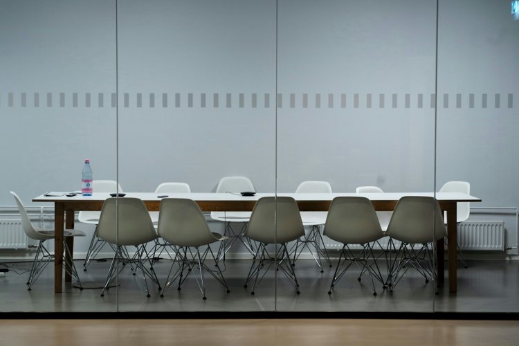 witte tafel met 10 witte stoelen eromheen